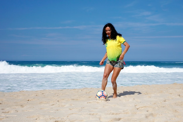 Donna che gioca a palla sulla spiaggia