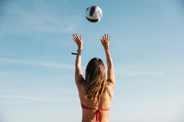 Donna che gioca a pallavolo in spiaggia