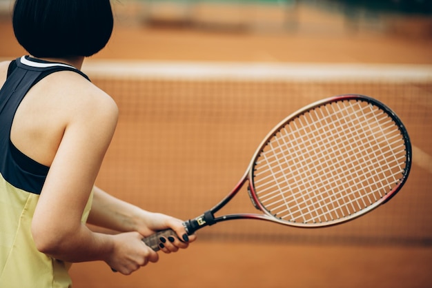 Donna che gioca a tennis alla corte