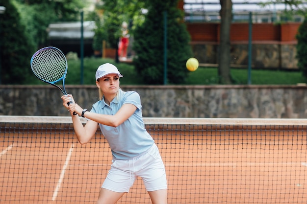 Donna che gioca a tennis e aspetta il servizio.