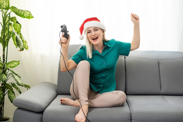 donna che gioca al videogioco sul divano in camera, capodanno e natale