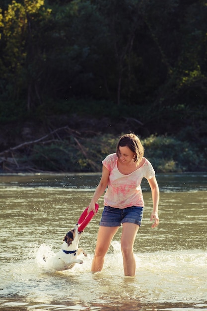 Donna che gioca con il cane in acqua