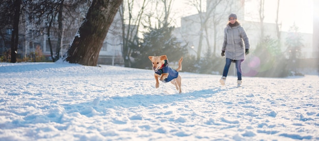 Donna che gioca con il cane nella neve