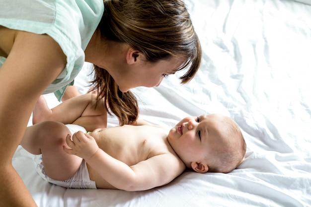 Donna che gioca con il figlio sul letto