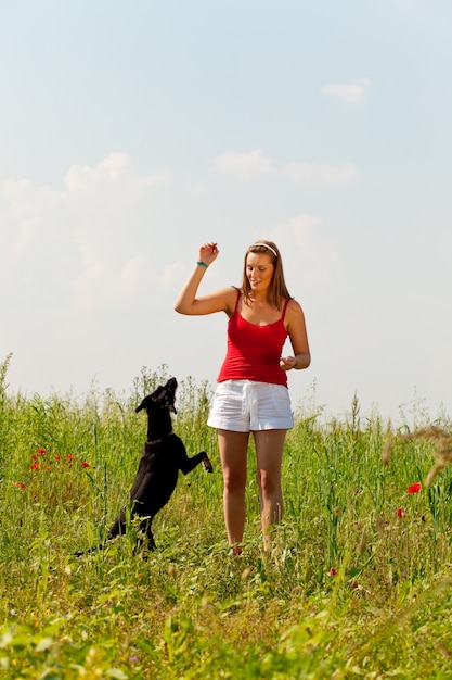 Donna che gioca con il suo cane in un prato