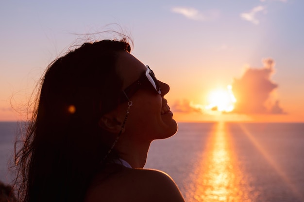 Donna che gode del tramonto sopra le vacanze estive del mare