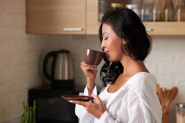 Donna che gode dell'odore del caffè