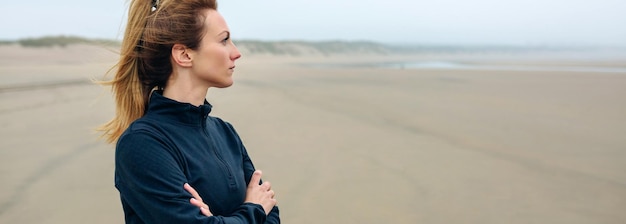 Donna che guarda da un'altra parte mentre è in piedi sulla spiaggia