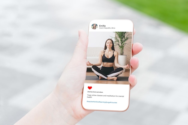 Donna che guarda foto di bellissime modelle che fa yoga sul cellulare