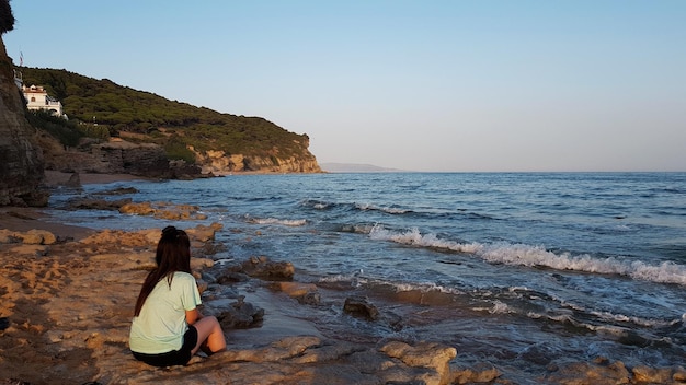 Donna che guarda il mare al tramonto