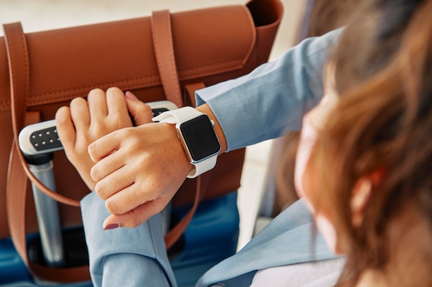 Donna che guarda il suo smartwatch mentre si trova in aeroporto durante la pandemia