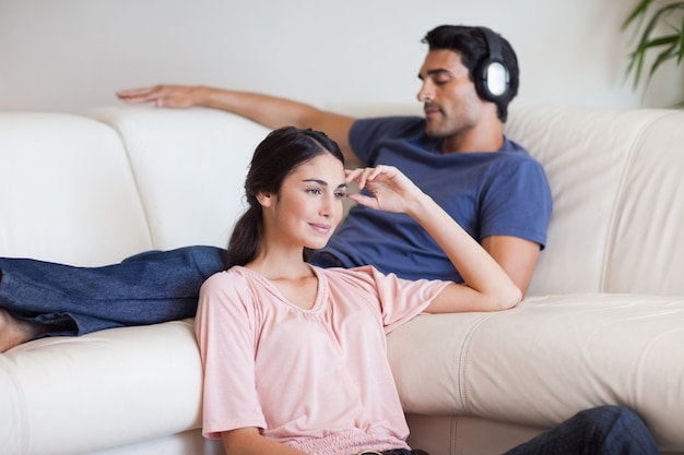 Donna che guarda la TV mentre suo marito ascolta musica