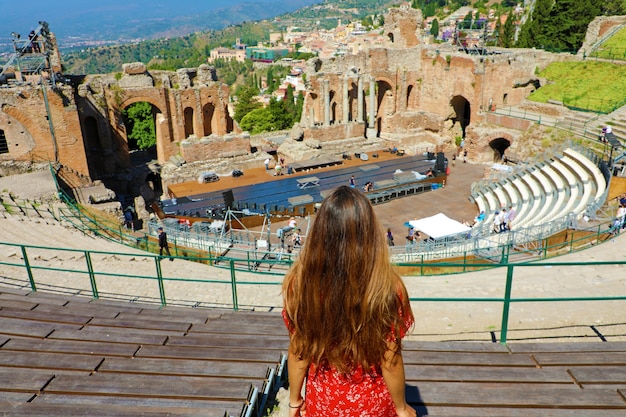 Donna che guarda le rovine dell'antico teatro greco di Taormina, Sicilia Italia