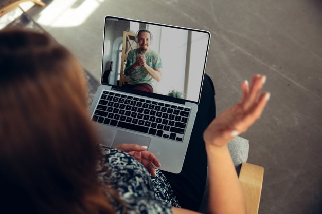 Donna che guarda un concerto di musica online a casa durante l'isolamento, quarantena COVID-19. Dispositivi, tecnologia e gadget. Intrattenimento e divertimento online, streaming di concerti. Prevenzione della diffusione del virus.