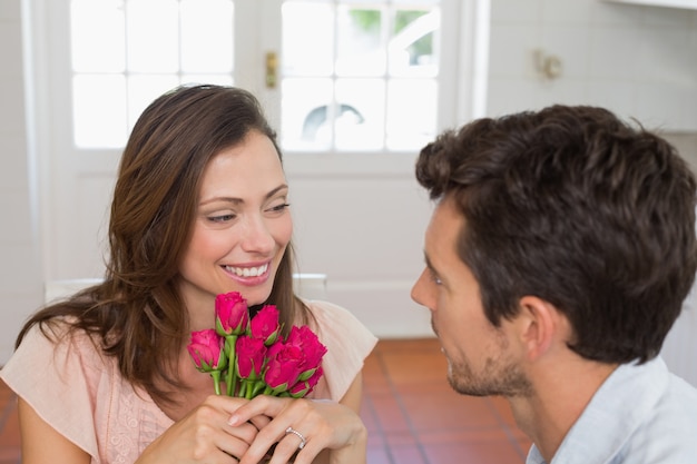 Donna che guarda uomo con fiori a casa