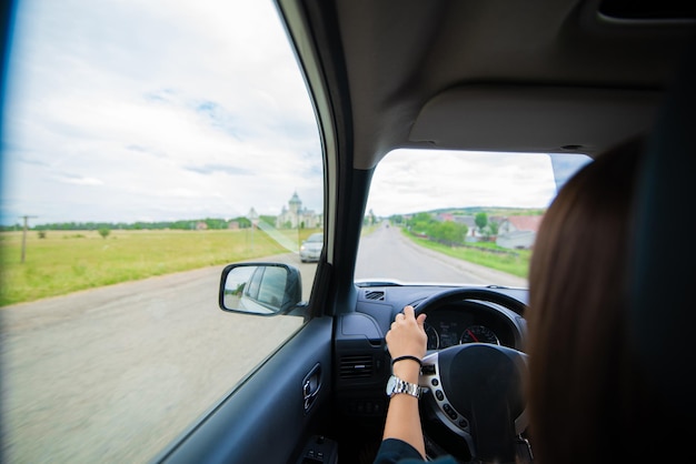 Donna che guida l'auto dal concetto di viaggio su strada estivo in autostrada
