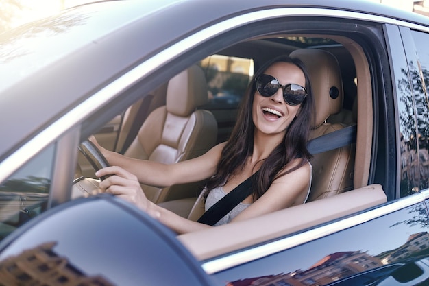 Donna che guida un'auto con il finestrino aperto