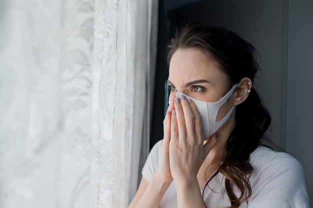 donna che ha paura di prendere una maschera antipolvere fredda e adulta, polvere di PM 2,5