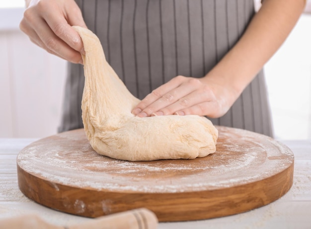 Donna che impasta la pasta sul tavolo della cucina