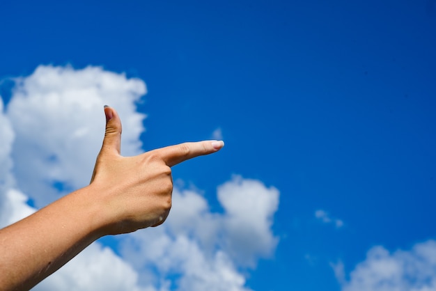 Donna che indica la sua mano e il cielo della nuvola