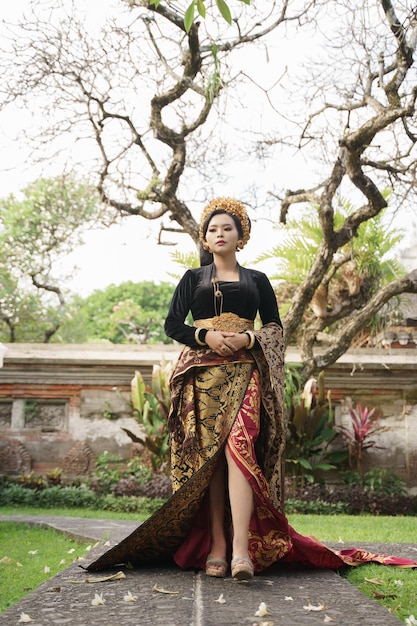 Donna che indossa il kebaya balinese con alberi sullo sfondo
