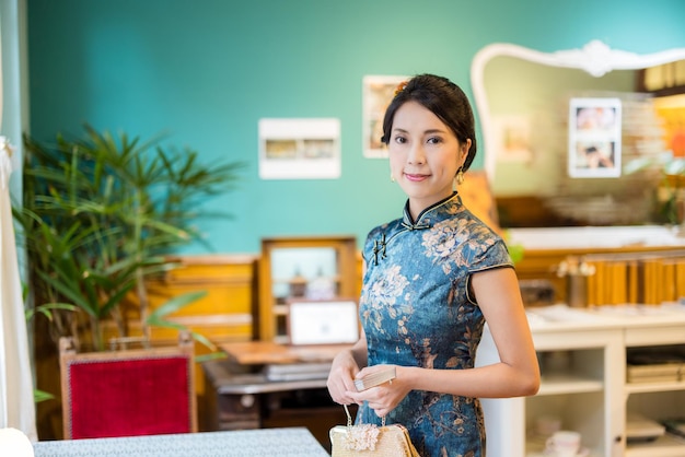 Donna che indossa il tradizionale cheongsam cinese nel ristorante vintage