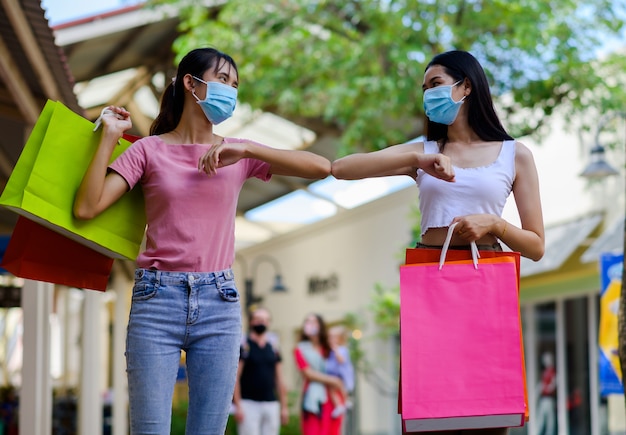 Donna che indossa la maschera per il viso shopping nel grande magazzino