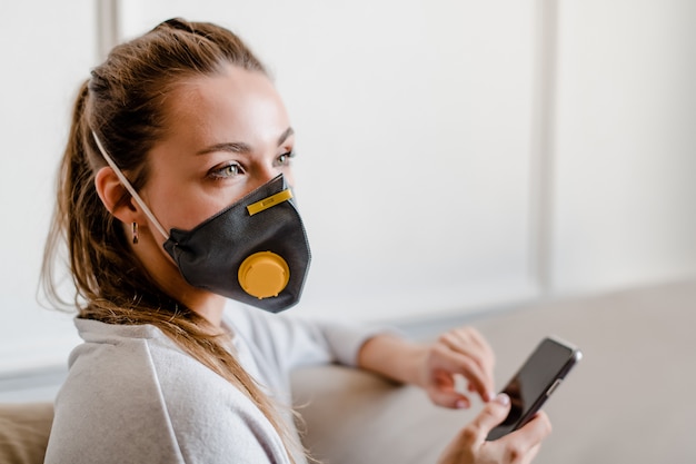 Donna che indossa maschera protettiva a casa sullo strato a casa