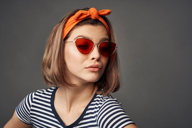 donna che indossa occhiali da sole in una maglietta a righe con una benda sulla testa che posa alla moda foto di alta qualità