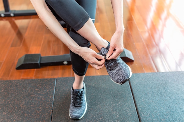 Donna che indossa scarpe da corsa in palestra