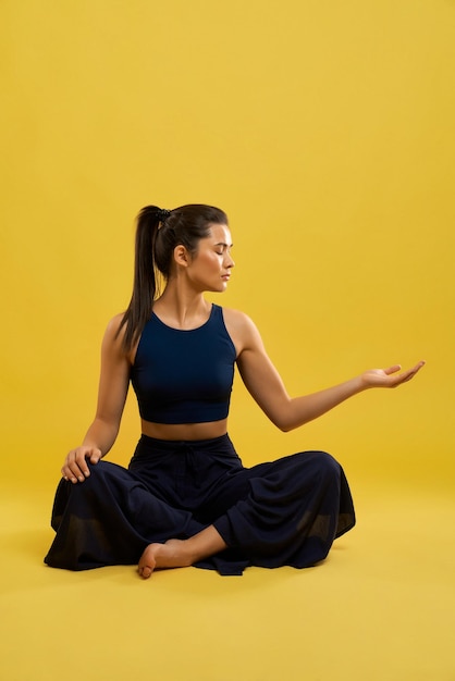 Donna che indossa un abito sportivo blu che fa yoga