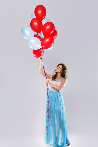 Donna che indossa un bel vestito con un sacco di palloncini colorati
