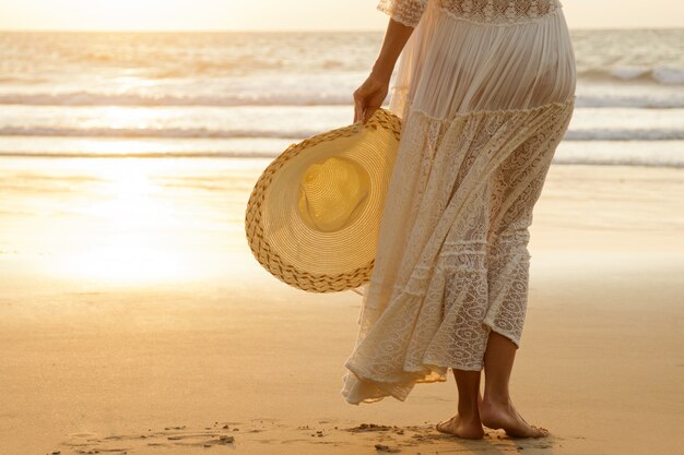 Donna che indossa un bellissimo abito bianco sulla spiaggia