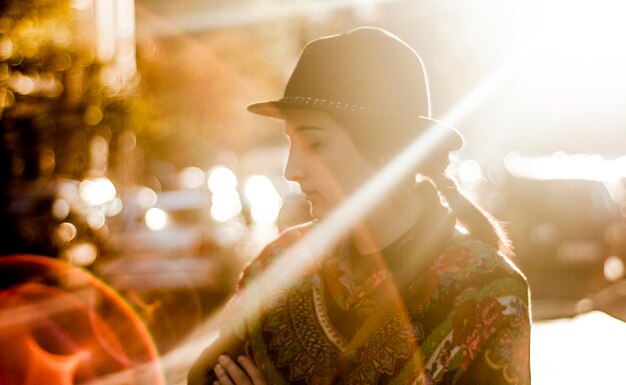 Donna che indossa un cappello che guarda lontano alla luce del sole