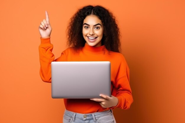 donna che indossa una maglietta arancione con un computer portatile isolato sullo sfondo arancione