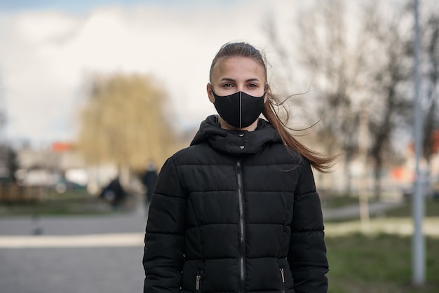 Donna che indossa una maschera a causa dell'inquinamento atmosferico o dell'epidemia di virus in città