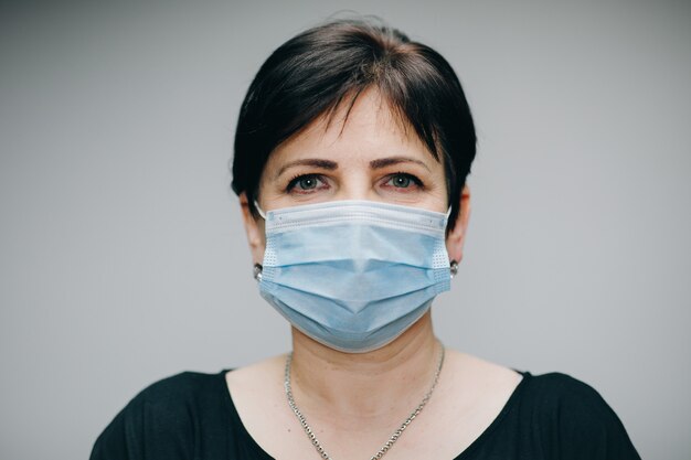 Donna che indossa una maschera medica durante l'epidemia di coronavirus COVID-19. Donna malata che indossa protezione durante la pandemia.