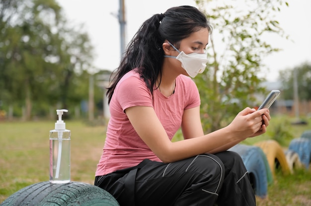 Donna che indossa una maschera per proteggere il virus corona covid19 per l'utilizzo del cellulare. concetto di assistenza sanitaria