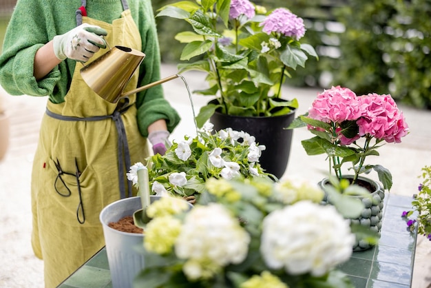 Donna che innaffia i fiori con l'annaffiatoio