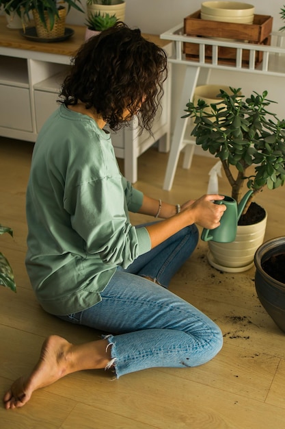 Donna che innaffia le piante in casa Fare i compiti Concetto di vita domestica