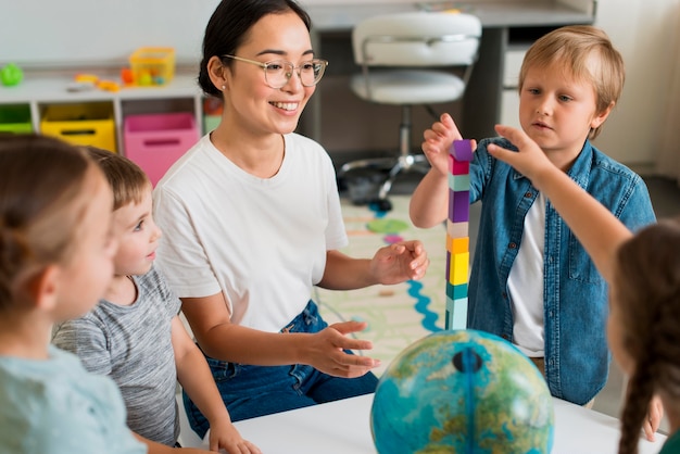 Donna che insegna agli studenti a giocare con la torre colorata