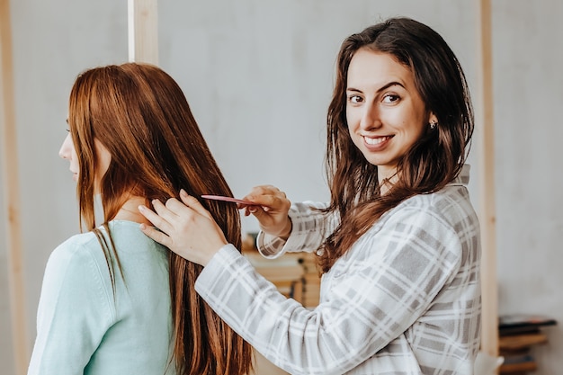 Donna che intreccia i capelli della sua amica