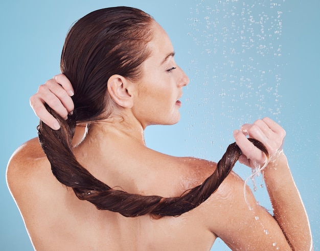 Donna che lava i capelli nella doccia e vista posteriore igiene e gocce d'acqua isolate su sfondo blu Governare cura cosmetica e sostenibilità persona femminile e routine mattutina shampoo e cura dei capelli