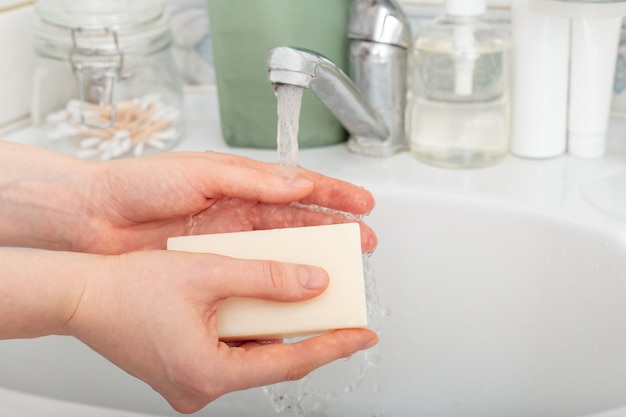 Donna che lava le mani con acqua e sapone antibatterico. Concetto di igiene delle mani.