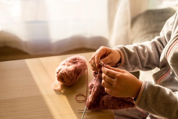 Donna che lavora a maglia a casa primo piano Hobby creativo Stile di vita fatto a mano
