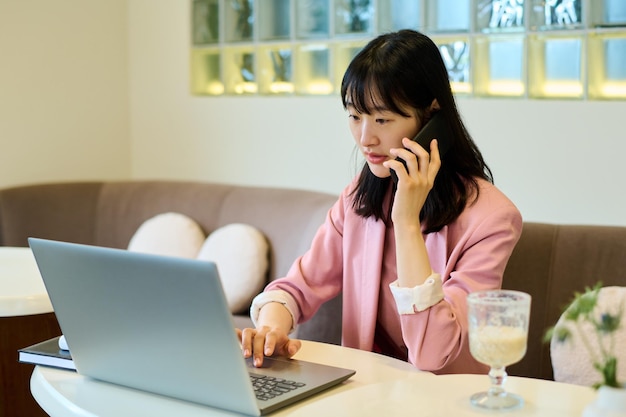 Donna che lavora al computer portatile al caffè