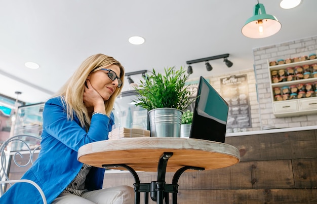 Donna che lavora con il computer portatile in una caffetteria