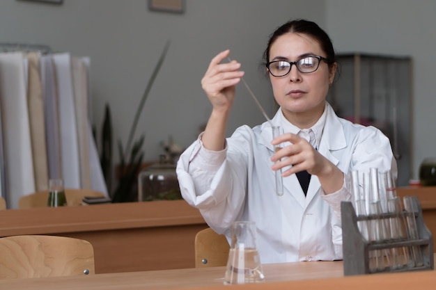 donna che lavora in laboratorio chimico o biologico con campioni in provette