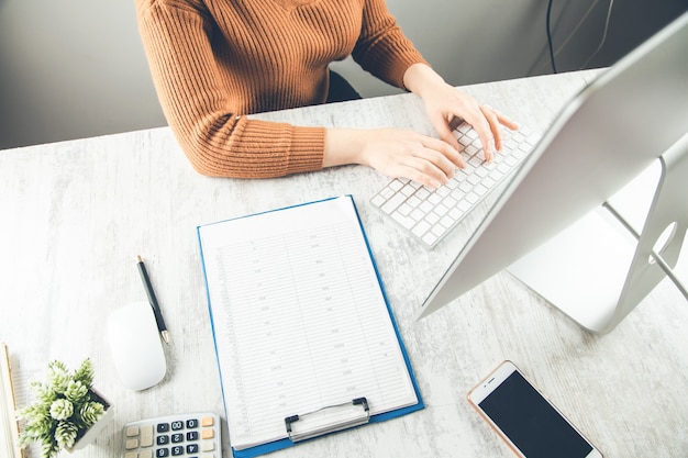 Donna che lavora nella tastiera del computer sulla scrivania