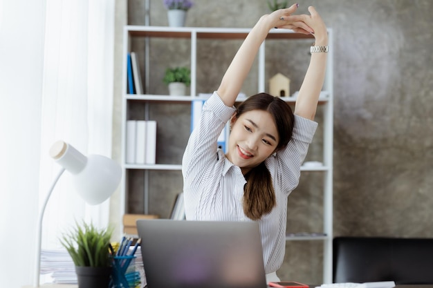 Donna che lavora rilassando una donna d'affari in ufficio si sta rilassando dopo aver lavorato duramente per molto tempo causando affaticamento e stress per prendersi una pausa ha la sindrome dell'ufficio Concetto di duro lavoro